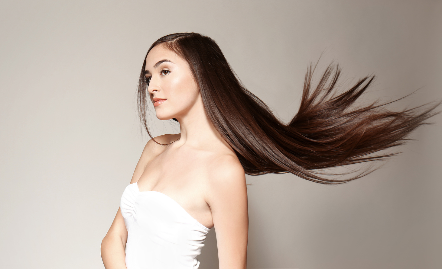 Young Woman with Long Straight Hair on Light Background